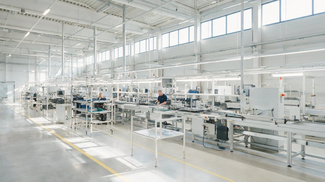 Modern production line in bright Hungarian factory with workers at stations