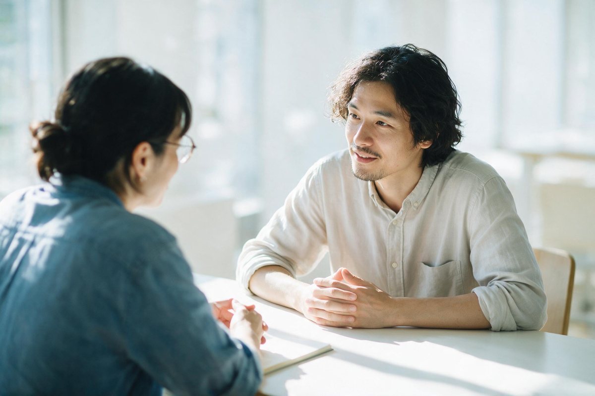 Two people in a calm honest conversation at a bright quiet table